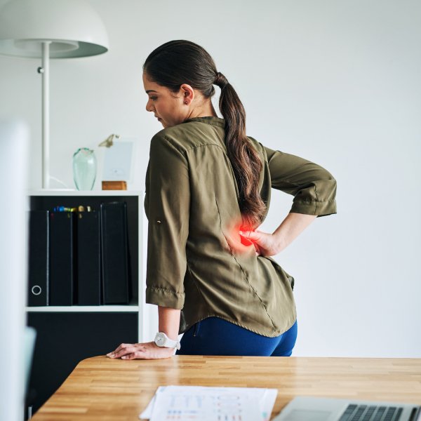 The image shows a woman in pain due to her bad standing posture.