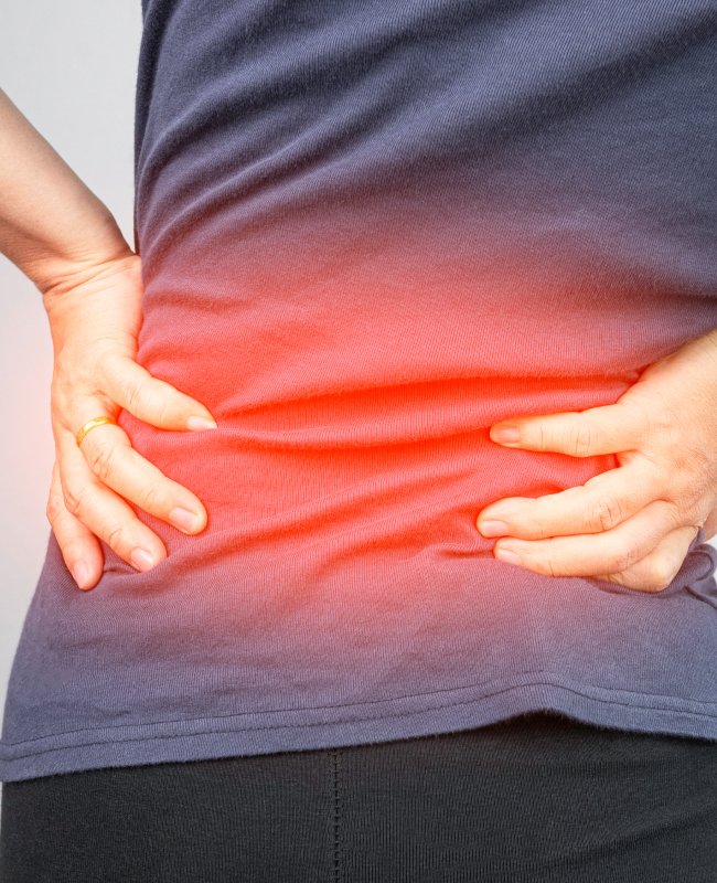 Image of a woman with back pain which is highlighted in red.